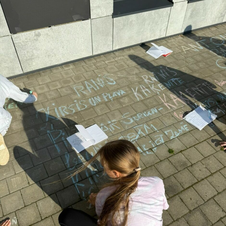 meitene zīmē uz asfalta