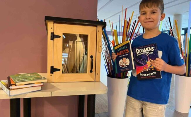 E.Supe pie grāmatu skapja