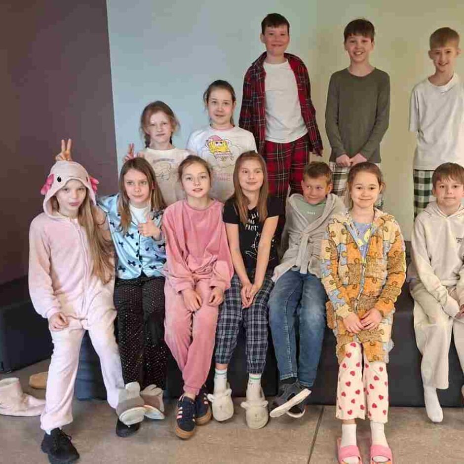 Bērnu grupa, kas tērpušies pidžamās, pozē fotogrāfijai.