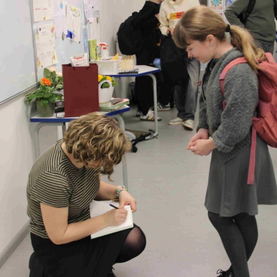 rakstniece sniedz autogrāfu