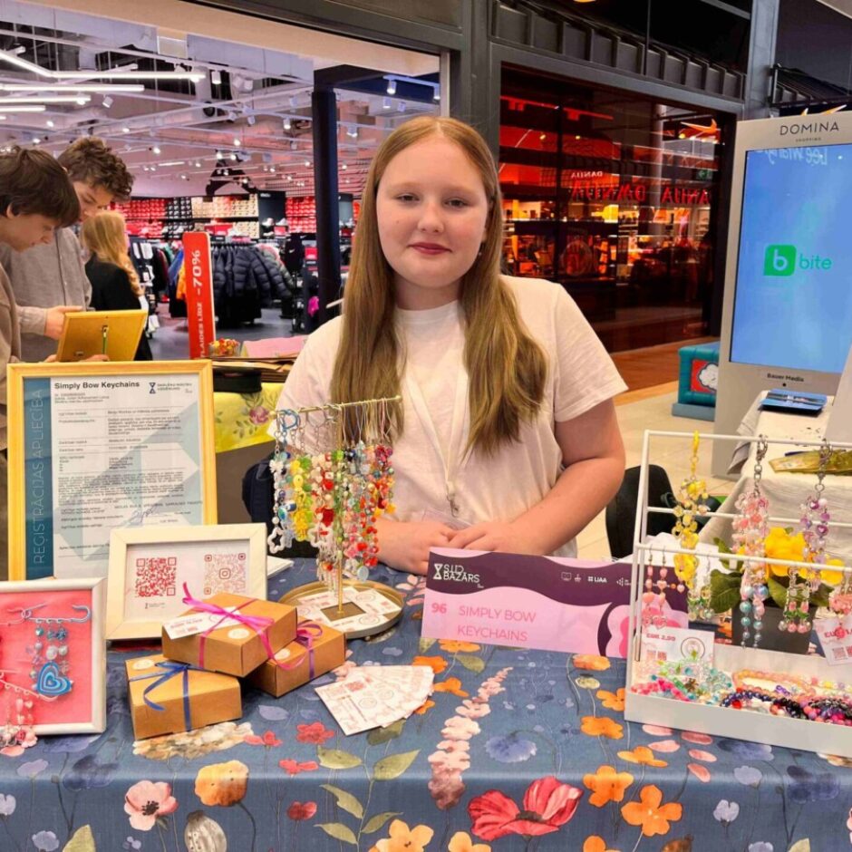 Simply Bow Keychains stends un Patrīcija Neimane