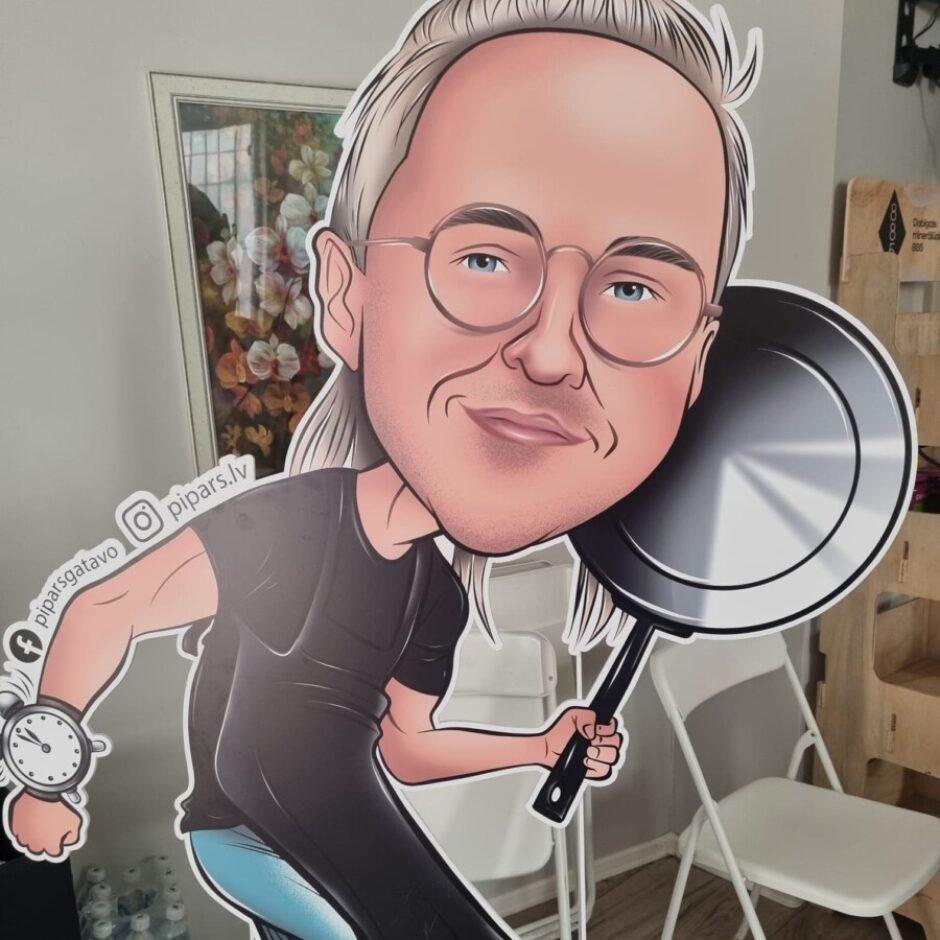 Liels kartona izgriezums, kas attēlo karikatūras vīrieti ar sirmiem matiem, brillēm, smaidu un zilu acīm. Viņš tērpies melnā T-kreklā un garā melnā priekšautā, labajā rokā tur lielu melnu pannu, bet uz kreisās rokas ir liels pulkstenis. Blakus pulkstenim redzams teksts 