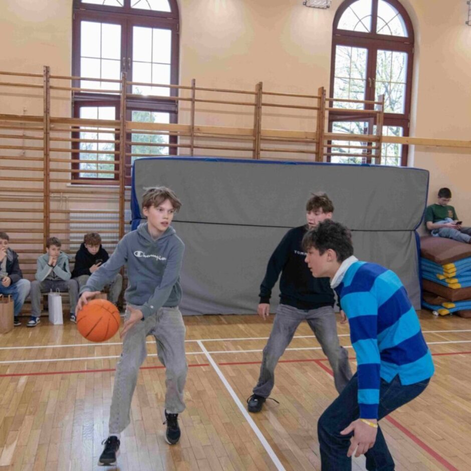 Skolēni spēlē basketbolu sporta zālē