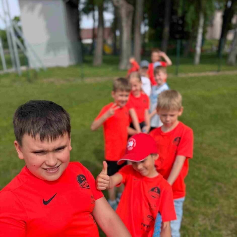 skolēnu grupa orandžos tkreklos